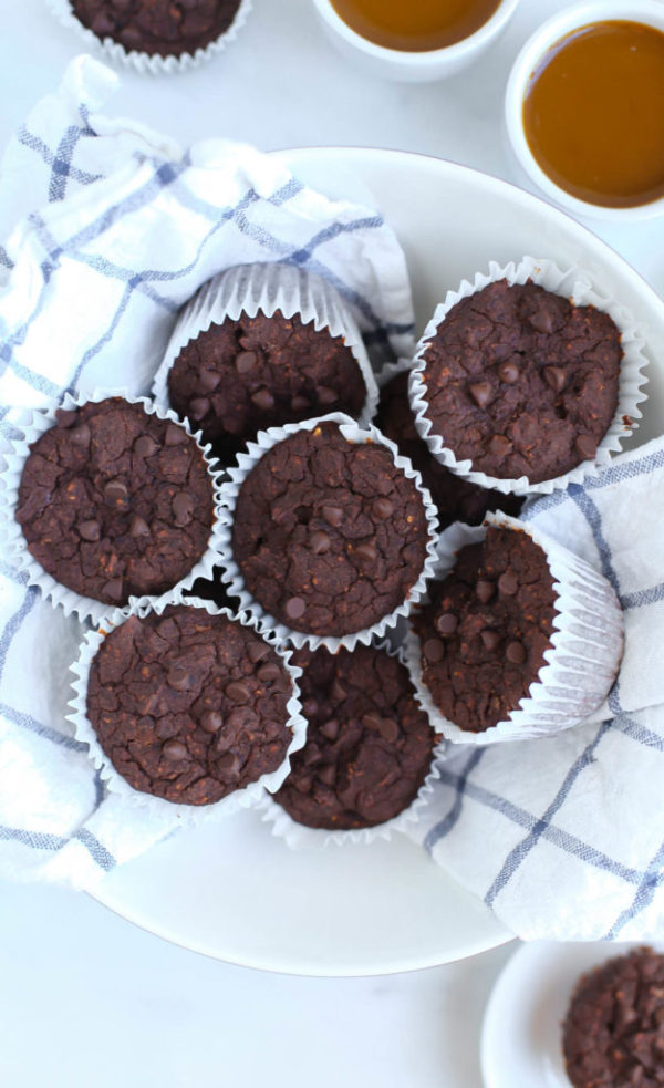 Chocolate black bean muffins sitting on a tea towel in a bowl