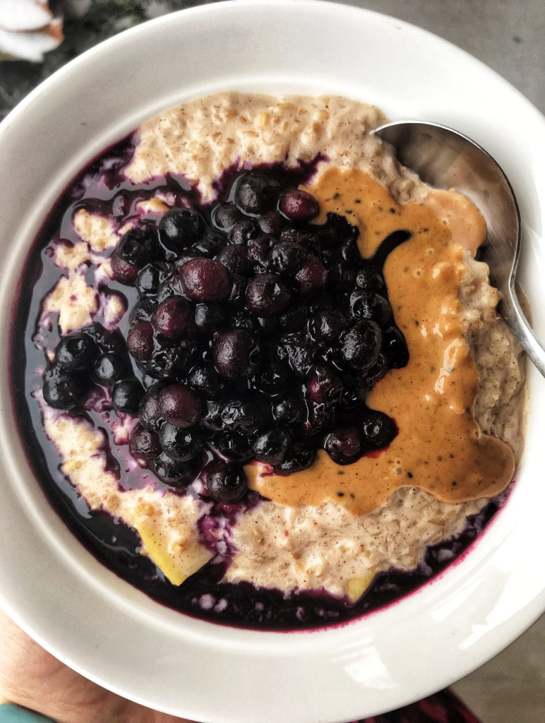 Ayurvedic oatmeal topped with peanut butter and blueberries