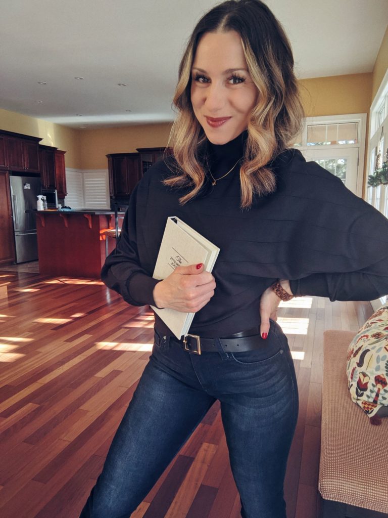 Natalie Pupo holding a book posing in a living room