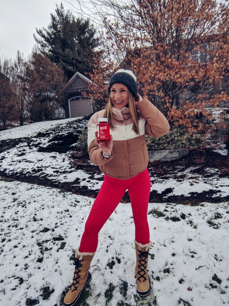 Natalie Pupo holding Goli Gummies outdoors in the snow