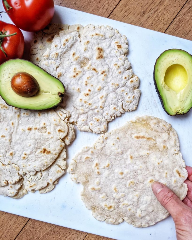 Grain-free tortillas with avocado and tomato on a cutting board